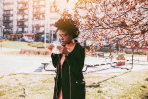 Woman sneezing in the blossoming garden
