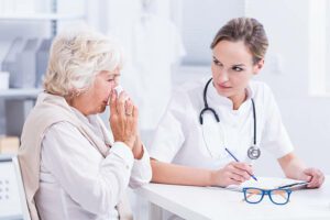 Senior woman during visit at allergist, doctor doing notes